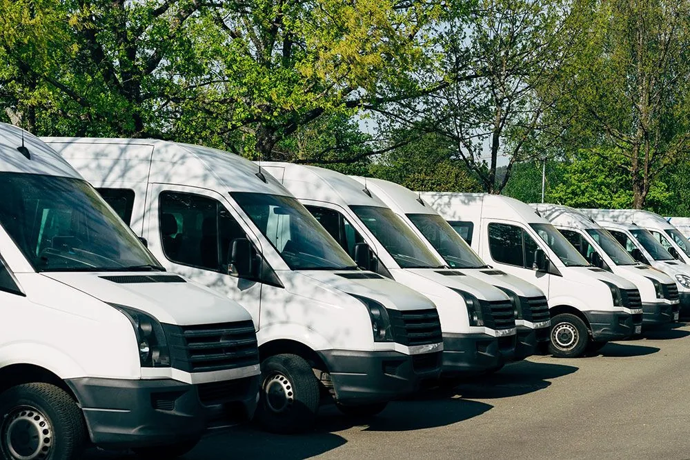 Row of white vans lined up and ready for dispatch